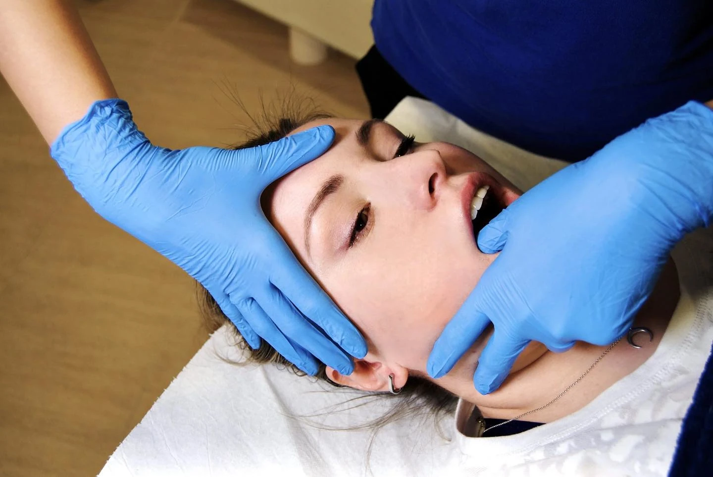 src-106001-tmj01 Therapist's gloved hands treating a patient's jaw